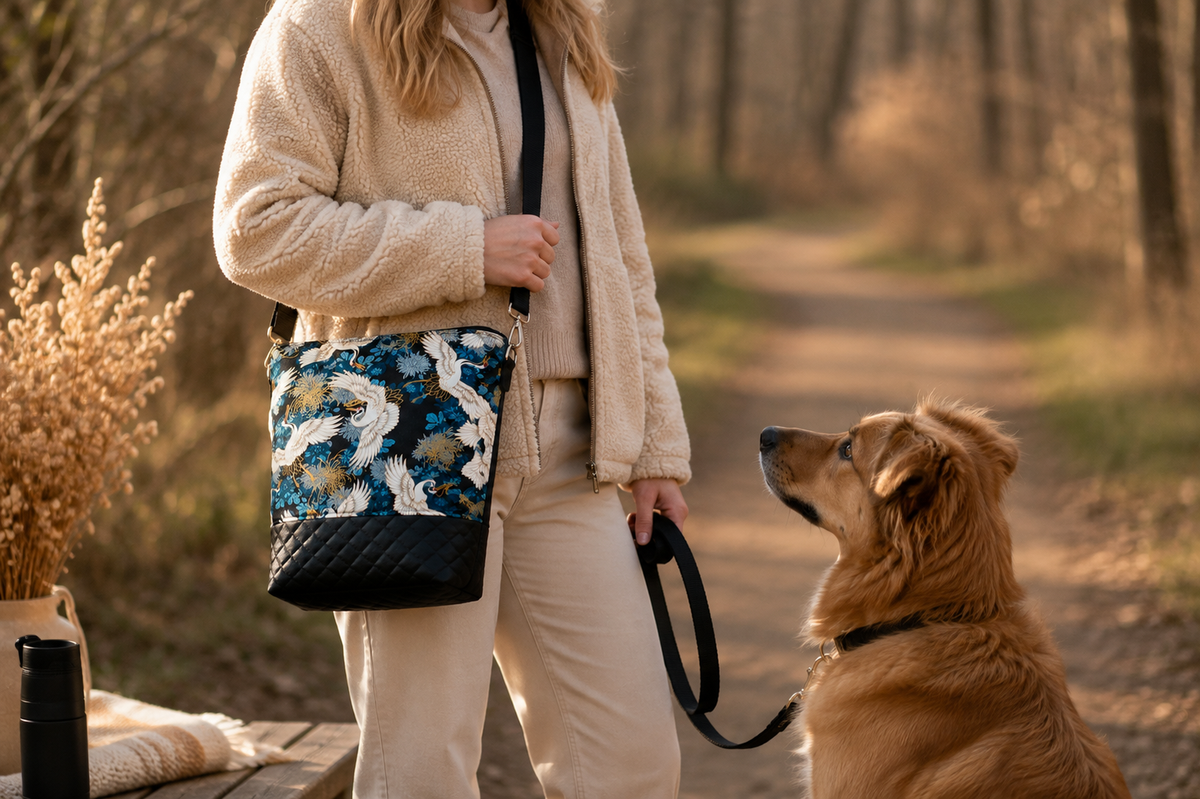 Gassitasche „Kranich“ beim Spaziergang mit Hund, getragen über der Schulter
