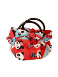 Handtasche „Panda“ aus rot-hellblauem Stoff mit niedlichem Panda-Muster, roten Stoffschleifen und dunkelbraunen runden Henkeln vor weißem Hintergrund.
