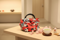 Furoshiki-Tasche „Panda“ mit rotem Panda-Motiv und schwarzen Kunststoffgriffen
